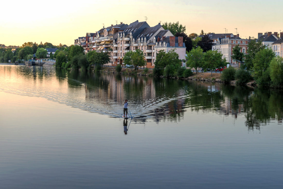 Un homme fait un sport nautique sur la Mayenne, en plein centre ville de Laval
